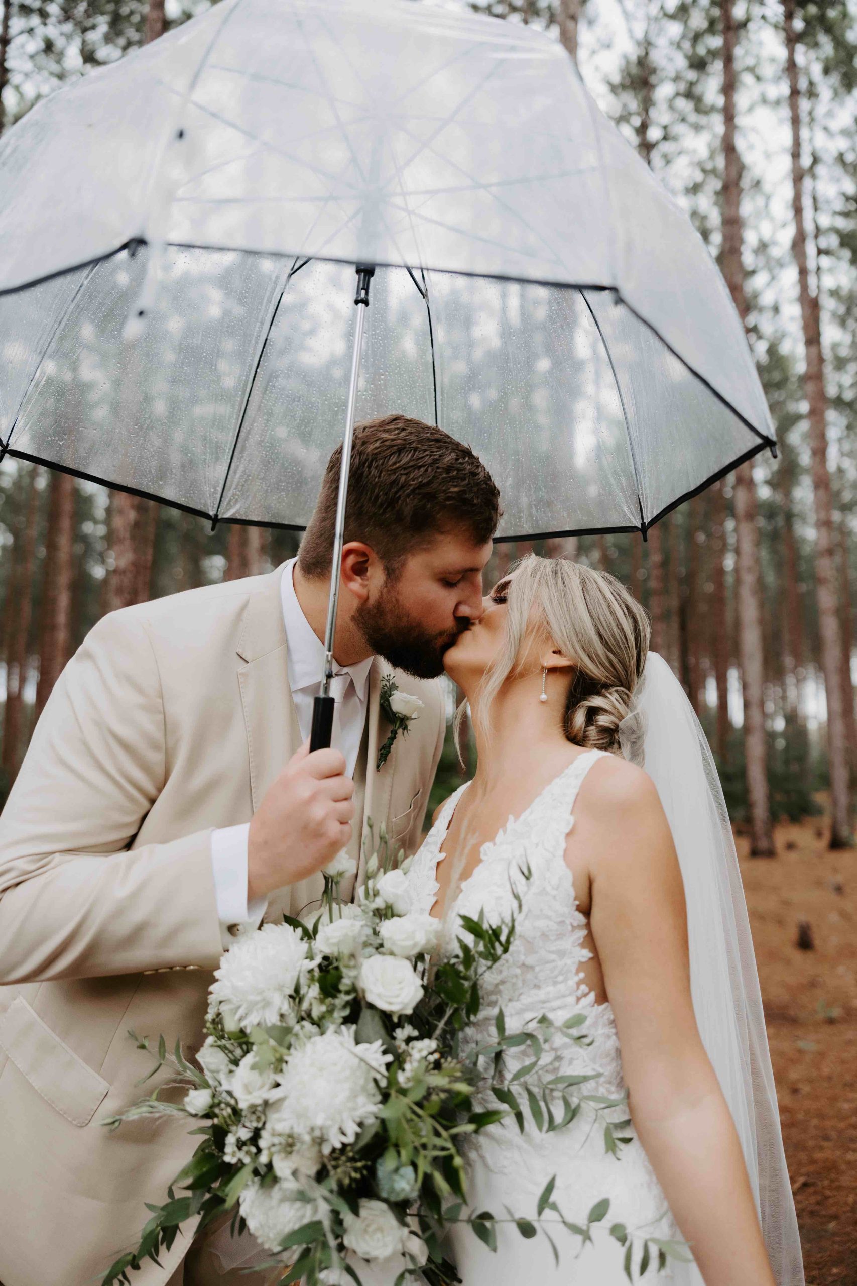 bride and groom kissing in rain